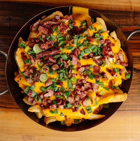 Sartén de papas fritas con cheddar, panceta y verdeo