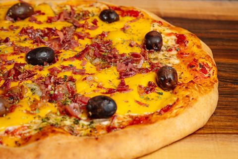 Pizza de muzza, cheddar y panceta con aceitunas negras