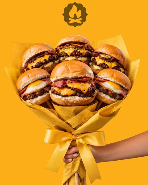 Un ramo de flores armado con hamburguesas, sobre fondo amarillo